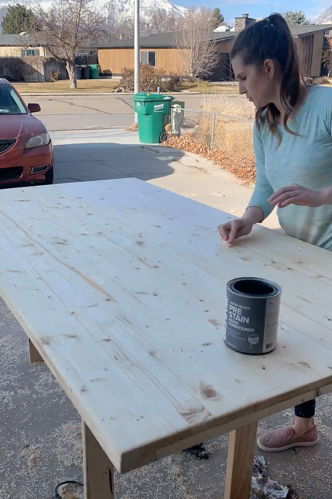 Using wood conditioner before staining a DIY kitchen table.